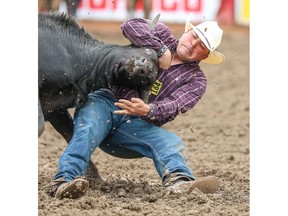 Craig Weisgerber of Ponoka, Alberta, planted his steer in a time of  4.7 seconds in the steer-wrestling event at the Calgary Stampede rodeo on Friday, July 5, 2019. Al Charest / Postmedia