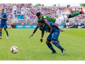 CavalryFC defender Nathan Mavila (3) lands on top of HFX Wanderers FC Attacker Akeem Garcia (11) while battling for the ball on Saturday in Halifax.