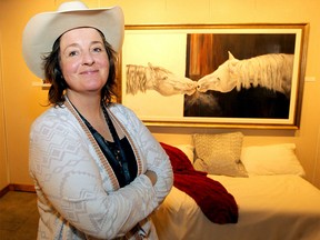 Artist Carolyn Sinclair poses for a photograph in front of one of her many equine abstract paintings on display in the Western Showcase located in the BMO Centre on Sunday, July 7, 2019. Brendan Miller/Postmedia