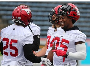 Calgary Stampeders running back Ka'Deem Carey, right, smiles while talking with fellow running back Don Jackson during practise at McMahon Stadium in Calgary in this June 27 file photo. File photo by Gavin Young/Postmedia.
