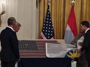 President Donald Trump looks at a U.S. flag with Dutch Prime Minister Mark Rutte(right) during an East Room ceremony at the White House in Washington on July 18, 2019. (NICHOLAS KAMM/AFP/Getty Images)