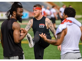 Calgary Stampeders quarterback Bo Levi Mitchell warms up by the field at McMahon Stadium as he spends time with team defensive backs coach Joshua Bell and Running Back Terry Williams during a team practice on Calgary on Friday, August 2, 2019. Azin Ghaffari/Postmedia Calgary