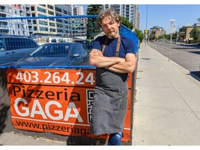 Nebojsa Zeljic takes a moment outside his restaurant, Pizzeria Gaga, on 12 Ave. S.W. on Thursday. Zeljic says a bike lane in front of his restaurant will harm his business as they will lose parking for their services and customers. Photo by Azin Ghaffari/Postmedia.