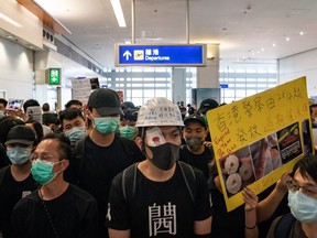 Protesters hold placards as they block the departure gate of the Hong Kong International Airport Terminal 2 during a demonstration on August 13, 2019 in Hong Kong, China. (Photo by Anthony Kwan/Getty Images)