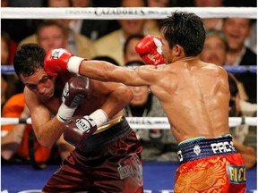 LAS VEGAS - DECEMBER 06:  Manny Pacquiao (R) hits Oscar De La Hoya in the fifth round of their welterweight bout at the MGM Grand Garden Arena December 6, 2008 in Las Vegas, Nevada.