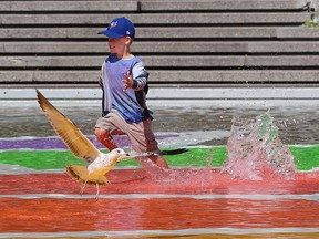 Cameron Ens, 5, plays in the water in Olympic Plaza in Calgary on Tuesday August 13, 2019. The pool appeared to have re-opened after being closed for health reasons. Gavin Young/Postmedia