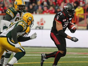 Calgary Stampeders' Jon Cornish, right, breaks away from three Edmonton Eskimos' players and runs for a touchdown during first half CFL Western Final action in Calgary, Alta., Sunday, Nov. 23, 2014. THE CANADIAN PRESS/Larry MacDougal