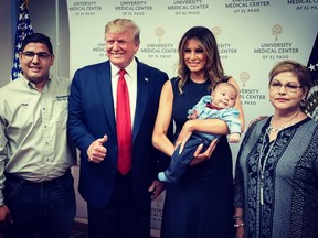 In this photo shared by First Lady Melania Trump, U.S. President Donald Trump is seen giving a thumbs up while posing for a photo with a baby boy orphaned after the El Paso shooting. (FLOTUS/Twitter)