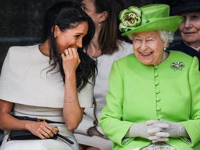 Queen Elizabeth sits and laughs with Meghan, Duchess of Sussex during a ceremony to open the new Mersey Gateway Bridge on June 14, 2018 in the town of Widnes in Halton, Cheshire, England. (Jeff J Mitchell/Getty Images)