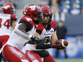 Calgary Stampeders quarterback Nick Arbuckle (9) hands off to Romar Morris (2) against the Winnipeg Blue Bombers during the first half of CFL action in Winnipeg Thursday, August 8, 2019. THE CANADIAN PRESS/John Woods