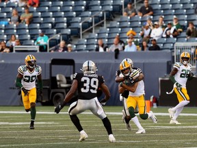 Green Bay Packers WR Trevor Davis is wrapped up by Oakland Raiders CB Nevin Lawson during NFL exhibition action at IG Field in Winnipeg on Thurs., Aug. 22, 2019.