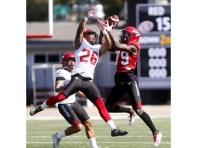 Calgary Stampeders Team Red Richard Sindani makes a nice catch with defender Team White Dagogo Maxwell on him during the Red and White game at McMahon stadium in Calgary on Sunday May 27, 2018. Darren Makowichuk/Postmedia