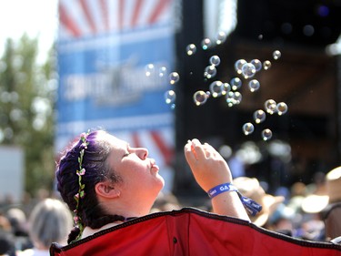 Country music fan Christine Stavrakis blows bubble on the second day of the Country Thunder music festival, held at Prairie Winds Park in Calgary Saturday, August 17, 2019. Dean Pilling/Postmedia