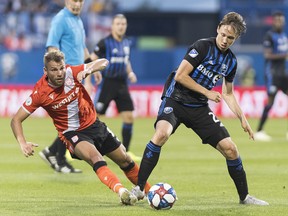 Montreal Impact's Lassi Lappalainen, right, challenges Cavalry Fc's Julian Buscher during first half semifinal Canadian Championship soccer action in Montreal, Wednesday, August 7, 2019. THE CANADIAN PRESS/Graham Hughes
