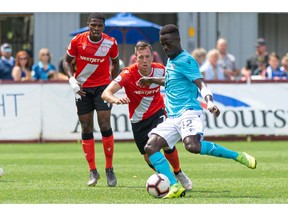 Canadian Premier League  - HFX Wanderers FC vs Cavalry FC - Wanderers Grounds, Halifax, Nova Scotia - August 10, 2019. HFX Wanderers FC Midfielder Mohammad Kourouma (12) looks to play the ball as CavalryFC Attacker Oliver Minatel (7) tries to defend.