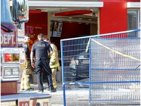 Calgary Fire and Police investigate after a car drove into the KFC on 17 Ave. and 12 St. S.W. in Calgary on Monday. Photo by Darren Makowichuk/Postmedia.