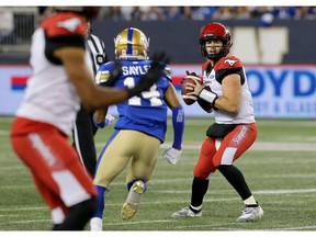 Calgary Stampeders quarterback Nick Arbuckle (right) spots a receiver with Winnipeg Blue Bombers defensive Marcus Sayles barrelling down on him during CFL action in Winnipeg on Thurs., Aug. 8, 2019. Kevin King/Winnipeg Sun/Postmedia Network