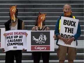 PETA supporters wearing horse masks protest in front of the Alberta Legislature on Tuesday, July 16, in Edmonton. Agriculture groups are calling for stricter law enforcement in the aftermath of a recent protest by animal activists at a turkey farm near Fort Macleod.