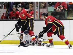 Steven Iacobellis of the Edmonton Oilers is caught up in the legs of Calgary Flame Martin Pospisil, #76, allowing his teammate Luke Philp, #48, to pick up the puck during the Young Guns Battle of Alberta game Saturday, Sept. 7, 2019 at the Westerner Park Centrium in Red Deer.