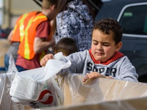 Zane, 6, helps unload the donations into the Calgary Food Bank boxes during the City-Wide Food Drive at Westbrook Mall in Calgary on  Saturday, September 14, 2019. Azin Ghaffari/Postmedia Calgary