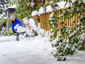 Yan Huang shovels the snow off the entrance of her house in Calgary on Monday, September 30, 2019. Azin Ghaffari/Postmedia Calgary