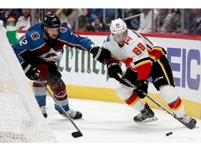 DENVER, COLORADO - APRIL 17:  Patrik Nemeth #12 of the Colorado Avalanche fights for the puck against Andrew Mangiapane #88 of the Calgary Flames in the first period during Game Four of the Western Conference First Round during the 2019 NHL Stanley Cup Playoffs at the Pepsi Center on April 17, 2019 in Denver, Colorado.