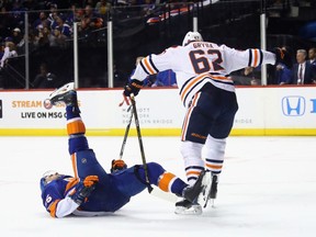 Johnny Boychuk #55 of the New York Islanders is tripped up by Eric Gryba #62 of the Edmonton Oilers during the second period at the Barclays Center on November 7, 2017 in the Brooklyn borough of New York City.