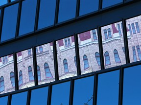 Windows of Calgary's City Hall reflect the construction wrap on the Old City Hall on Tuesday September 3, 2019.  Gavin Young/Postmedia