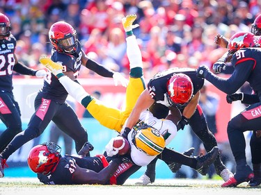 Edmonton Eskimos Natey Adjei is tackled by Cordarro Law and Cory Greenwood Calgary Stampeders during CFL football in Calgary on Monday, September 2, 2019. Al Charest/Postmedia
