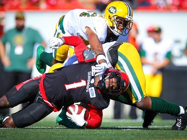 Calgary Stampeders Hergy Mayala is tackled by Larry Dean and Monshadrik Hunter of the Edmonton Eskimos during CFL football in Calgary on Monday, September 2, 2019. Al Charest/Postmedia