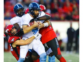 Toronto Argonauts quarterback McLeod Bethel-Thompson is sacked by Nate Holley and Cordarro Law of the Calgary Stampeders  during CFL football in Calgary on Thursday, July 18, 2019. Al Charest/Postmedia