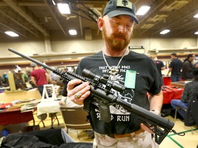 Collector/ gun enthusiast Tyson Colleton holds up a Aero Survival Rifle (9mm) at "The Finest Little Gun Show in the West (Calgary)" at the Thorncliff Community Centre in northeast Calgary on Saturday, September 21, 2019. Jim Wells/Postmedia