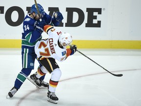 Calgary Flames forward Austin Czarnik checks Vancouver Canucks defenceman Josh Teves during a pre-season game in Victoria, B.C., on Sept. 16, 2019.