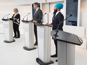 An empty podium is seen as Green Party Leader Elizabeth May, left, Conservative Leader Andrew Scheer, centre, and NDP Leader Jagmeet Singh get ready to take part during the Maclean's/Citytv National Leaders Debate in Toronto on Thursday, September 12, 2019. Liberal Leader Justin Trudeau turned down the invitation for the debate.