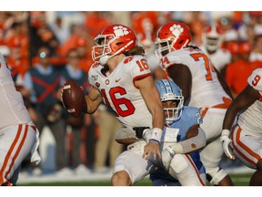 North Carolina Tar Heels linebacker Chazz Surratt (21) tries to tackle Clemson Tigers quarterback Trevor Lawrence (16) in the second half at Kenan Memorial Stadium. The Clemson Tigers won 21-20. Nell Redmond-USA TODAY