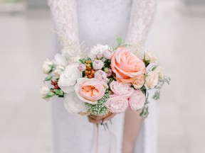 The bride holding wedding bouquet of roses,peonies and eustoma