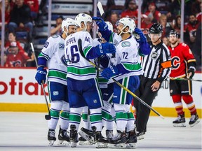 Sep 16, 2019; Calgary, Alberta, CAN; Vancouver Canucks defenseman Mitch Eliot (72) celebrates with teammates after scoring a goal against the Calgary Flames during the third period at Scotiabank Saddledome.