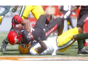 Calgary Stampeders, Ka'Deem Carey is tackled by Edmonton Eskimos, Larry Dean in first half action in the Labour Day classic at McMahon stadium in Calgary on Monday, September 2, 2019. Darren Makowichuk/Postmedia