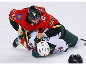 The Calgary Flames' Ryan Lomberg retaliates against the Minnesota Wild's Matt Dumba during NHL action at the Scotiabank Saddledome in Calgary on Thursday December 6, 2018.  Gavin Young/Postmedia
