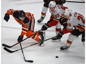 Edmonton Oilers Patrick Russell (52) tries to swipe the puck away from Calgary Flames Michael Stone (26) and Sam Bennett (93) during pre-season NHL action at Rogers Place in Edmonton, September 20, 2019. Ed Kaiser/Postmedia
