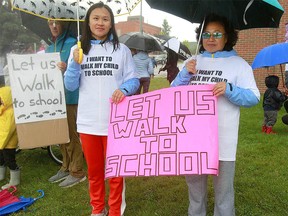 Yuping Wang stands with her mother Hong Fang He as part of a  group of Bridgeland parents protesting changes to the priority enrollment process for Langevin Elementary and Junior High School. Monday, September 9, 2019. Dean Pilling/Postmedia