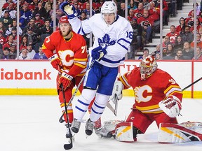 Mitch Marner of the Toronto Maple Leafs jumps to avoid a shot in front of David Rittich on March 4, 2019, at the Saddledome.