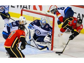 Calgary Flames Andrew Mangiapane attempts the wrap - around on goalie Eric Comrie of the Winnipeg Jets during pre-season NHL hockey in Calgary on Tuesday September 24, 2019. Al Charest / Postmedia