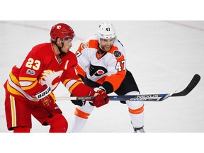 Calgary Flames' Sean Monahan battles against Andrew MacDonald of the Philadelphia Flyers during NHL hockey in Calgary, Alta., on Wednesday, February 15, 2017. AL CHAREST/POSTMEDIA