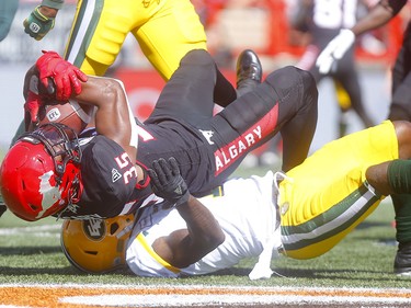 Calgary Stampeders, Ka'Deem Carey is tackled by Edminton Eskimos, Larry Dean in first half action in the Labour Day classic at McMahon stadium in Calgary on Monday, September 2, 2019. Darren Makowichuk/Postmedia
