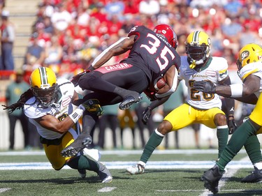 Calgary Stampeders, Ka'Deem Carey is tackled by a Edminton Eskimos, Don Unamba in first half action in the Labour Day classic at McMahon stadium in Calgary on Monday, September 2, 2019. Darren Makowichuk/Postmedia