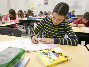 Kelly Fife writes during a Grade 7 class at West Ridge School in Calgary, Alta., on Monday, Jan. 9, 2017. In just its fourth day of operation, West Ridge School was the poster child for a Calgary Board of Education media availability to tout the opening of 15 new schools this school year. Lyle Aspinall/Postmedia Network