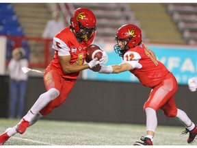 Dino's Receiver Jalen Philpot receives a hand off from Quarterback Adam Sinagra during the 2nd half of action as the U of C Dino's beat the University of Manitoba Bisions 24-10 at McMahon Stadium on Friday, September 6, 2019. Brendan Miller/Postmedia