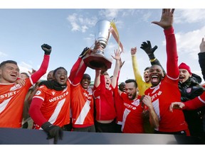 Cavalry FC players hoist the Wildrose Cup after winning 3-1 during CPL soccer action between FC Edmonton and Cavalry FC at ATCO Field at Spruce Meadows in Calgary on Saturday, October 19, 2019. Cavalry won both the spring and fall season and will play Forge FC in the league  finals. Jim Wells/Postmedia
