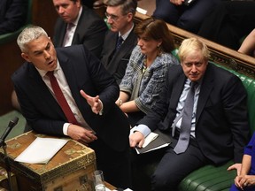 A handout picture released by the UK Parliament shows Britain's Secretary of State for Exiting the European Union (Brexit Minister) Stephen Barclay (L) speaking in the House of Commons in London on October 19, 2019, during a debate on the Brexit deal. - A day of high drama in parliament on Saturday saw lawmakers vote for a last-minute amendment to the deal that could force the government to seek to extend the October 31 deadline to leave. (Photo by JESSICA TAYLOR / UK PARLIAMENT / AFP) / RESTRICTED TO EDITORIAL USE - MANDATORY CREDIT " AFP PHOTO / UK PARLIAMENT / JESSICA TAYLOR " - NO USE FOR ENTERTAINMENT, SATIRICAL, MARKETING OR ADVERTISING CAMPAIGNS - EDITORS NOTE THE IMAGE HAS BEEN DIGITALLY ALTERED AT SOURCE TO OBSCURE VISIBLE DOCUMENTS /